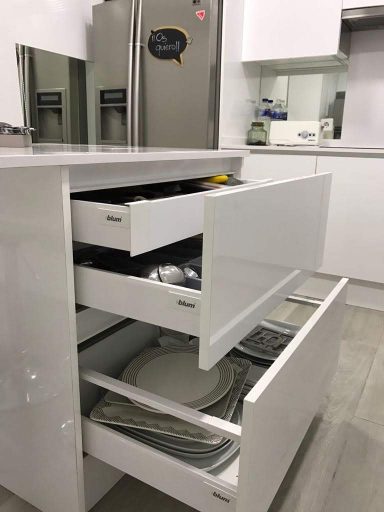  Cajones de cocina abiertos con platos y utensilios organizados.